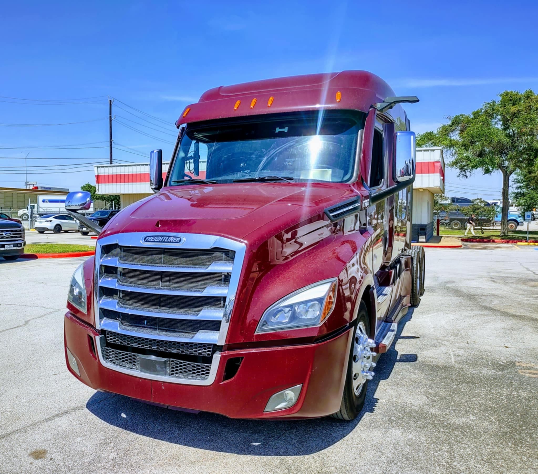 IHVI LLC burgundy Freightliner Cascadia semi-truck